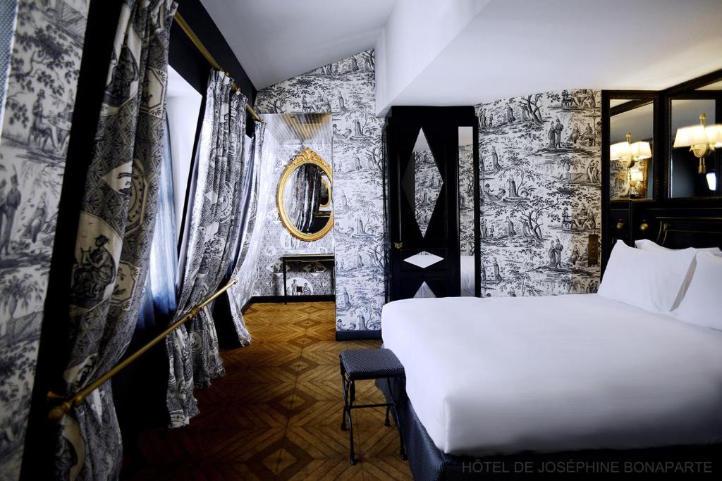 a bedroom with a white bed and a black and white wall at Hôtel de Joséphine BONAPARTE in Paris