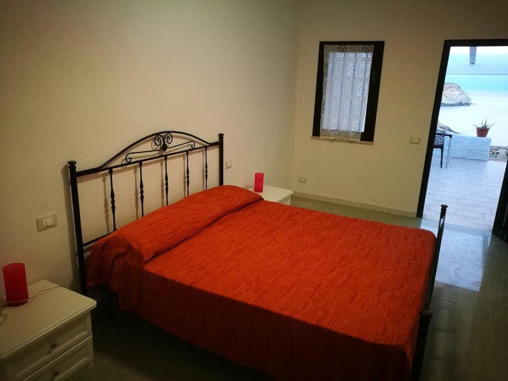 a bedroom with a bed with an orange bedspread at Oasi Di Casablanca in Lampedusa