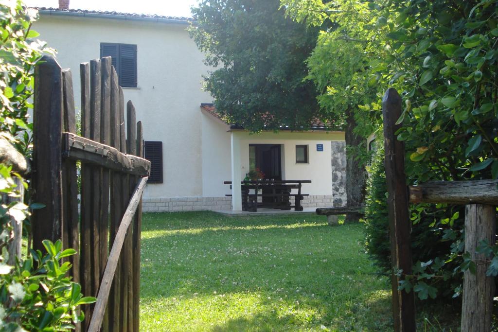 une clôture devant une maison dans l'établissement Apartmani Aldo, à Roč