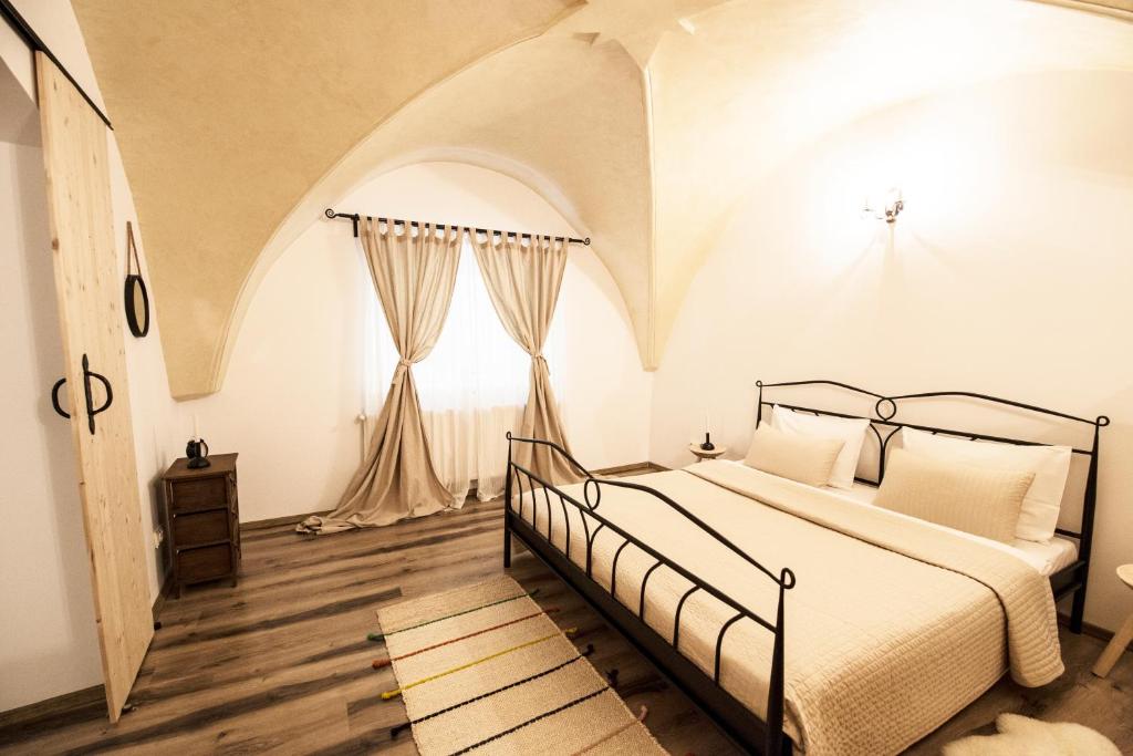 a bedroom with a bed and a large window at Gothic Apartment in Braşov