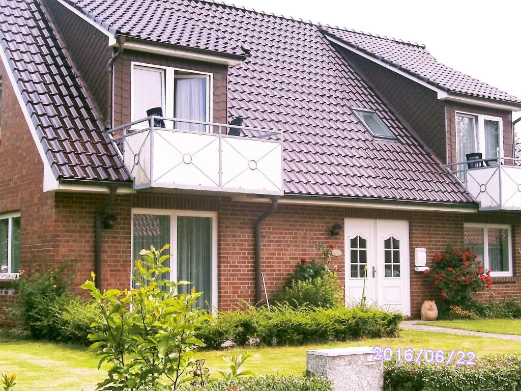 a red brick house with a white balcony at Haus Sonja in Büsum
