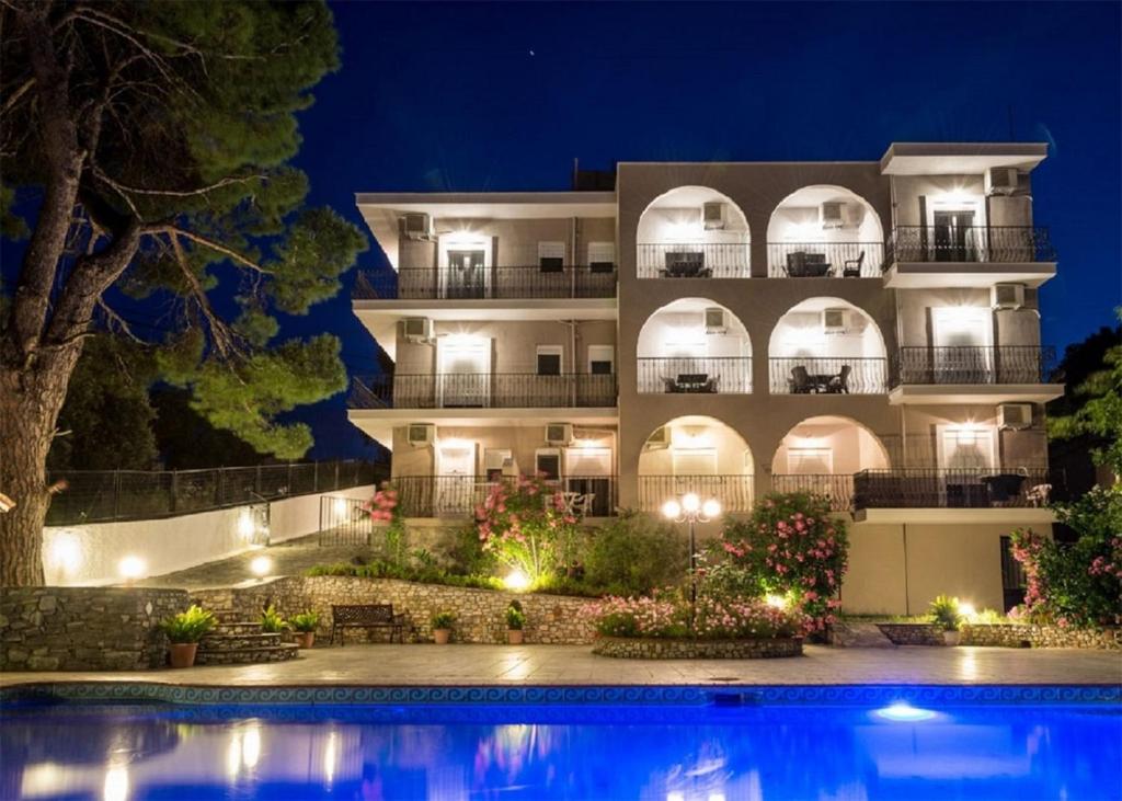 um edifício com uma piscina em frente à noite em Villa Albanis em Kolios