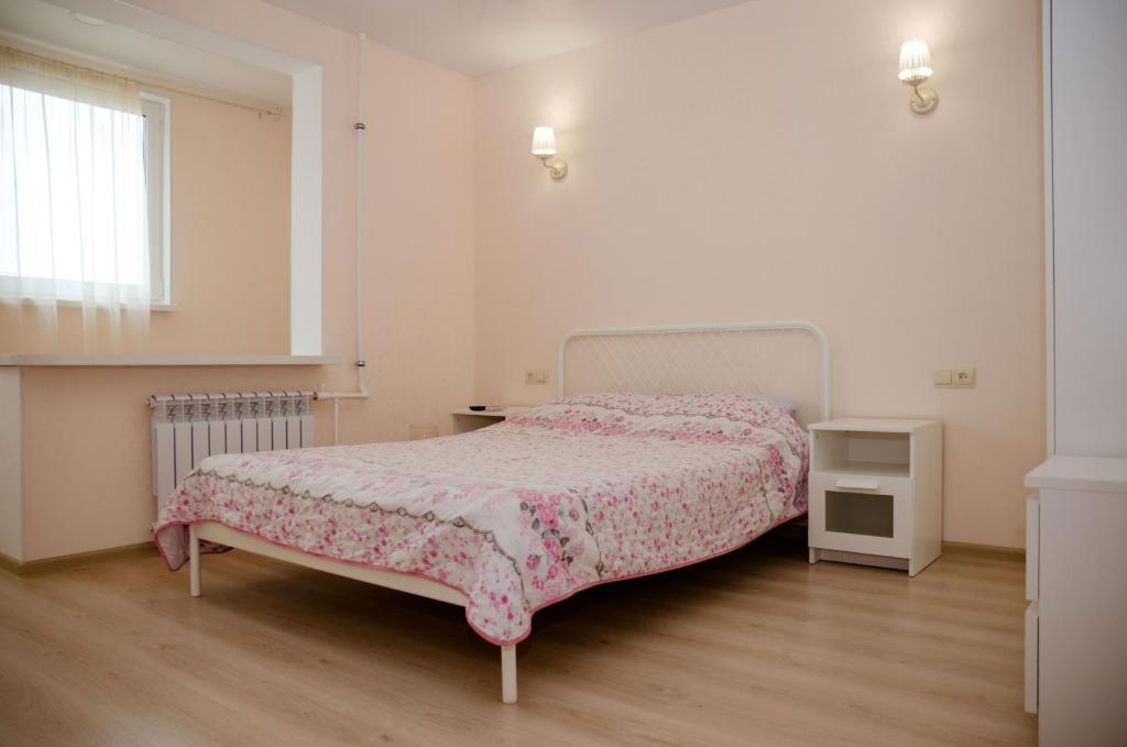 a white bedroom with a bed with a pink blanket at Апартаменты посуточно in Sevastopol