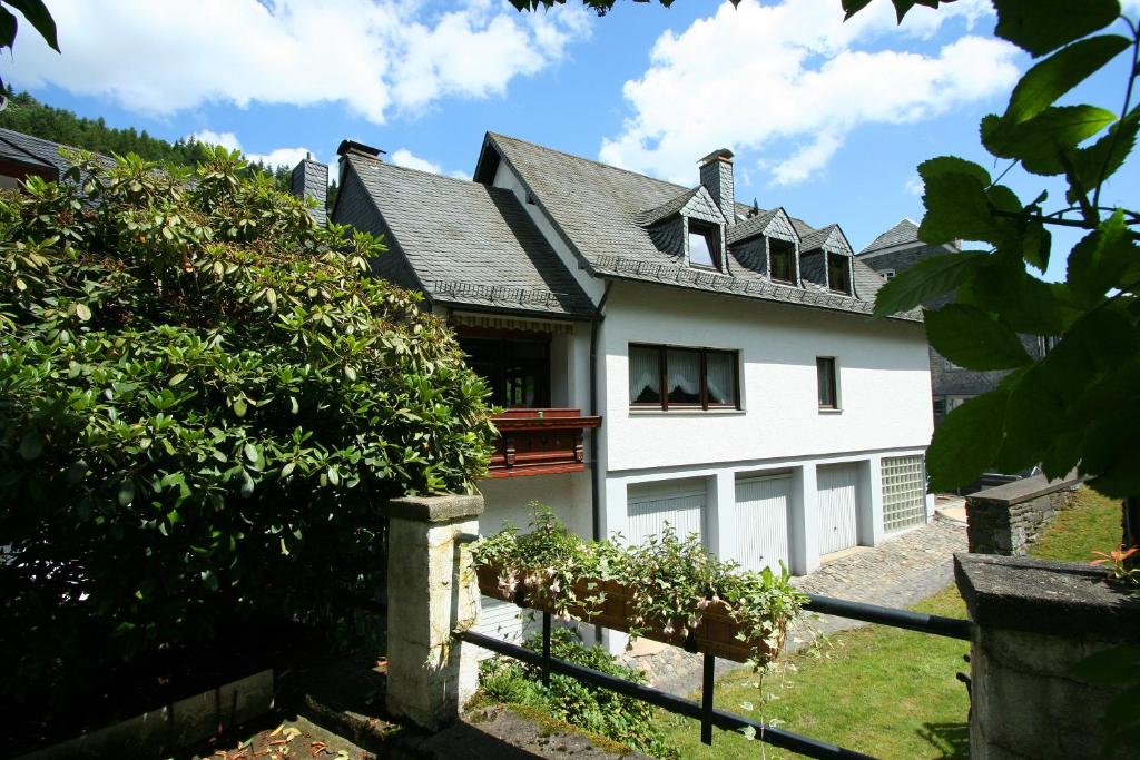 ein weißes Haus mit Fenstern und einem Zaun in der Unterkunft Ferienhaus Mühlenberg in Monschau