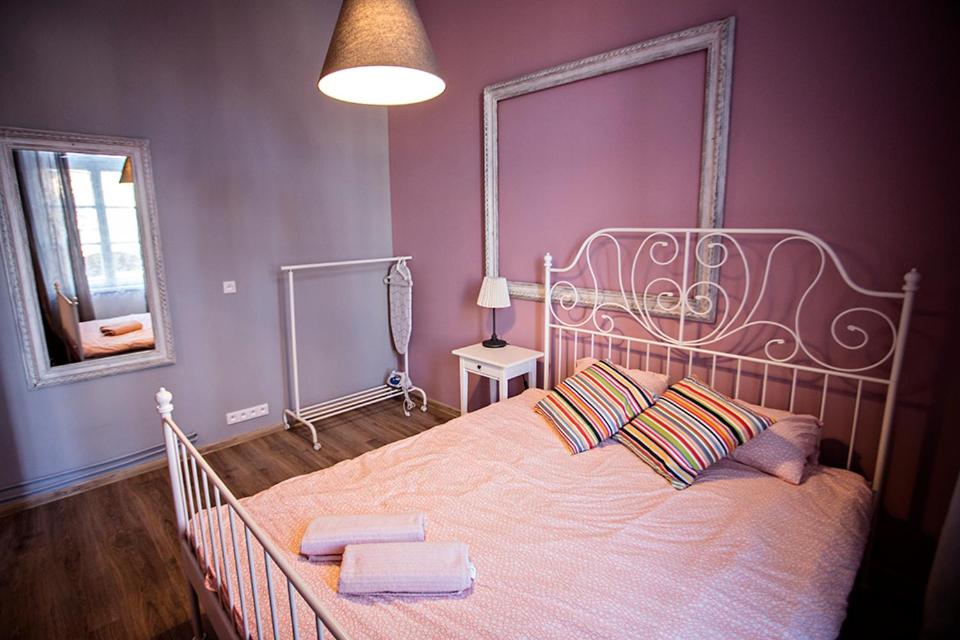 1 dormitorio con 1 cama grande y paredes moradas en Apartamenty Nowy Rynek, en Bydgoszcz