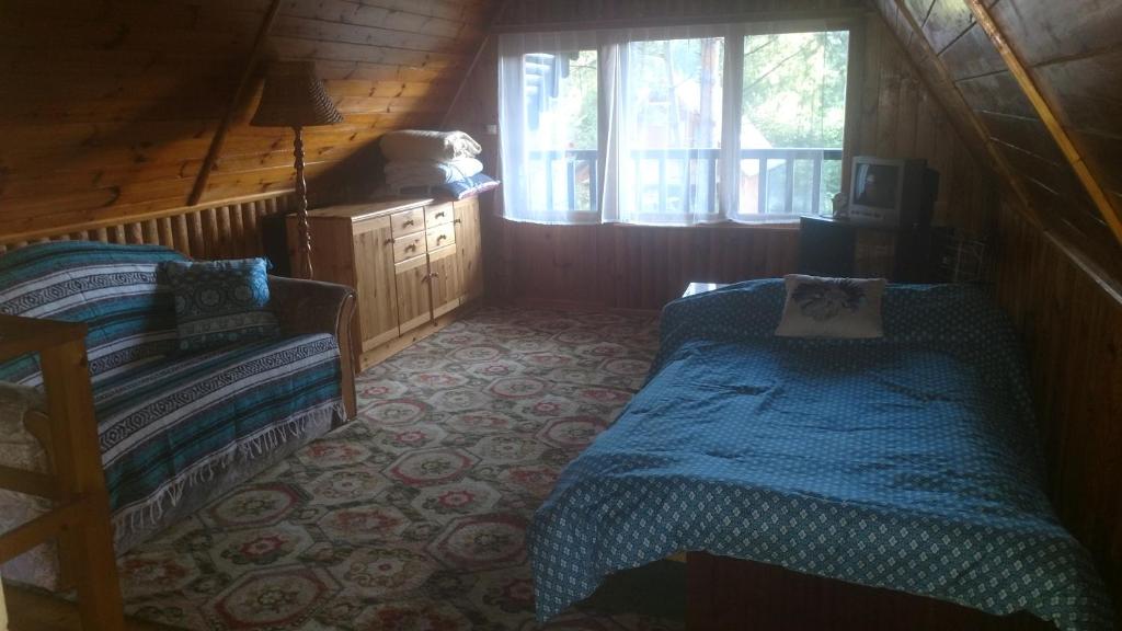 - une chambre avec 2 lits dans une cabane en rondins dans l'établissement Domek letniskowy Woryty, à Woryty