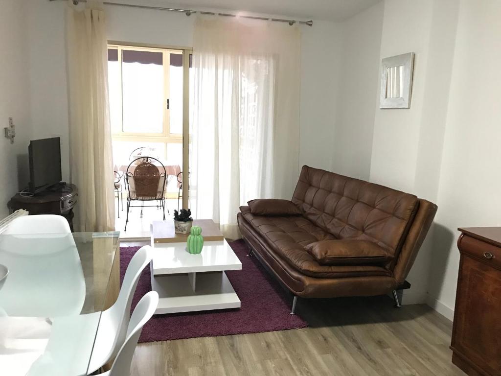 salon z brązową skórzaną kanapą i stołem w obiekcie mar y golf en muchavista w Alicante