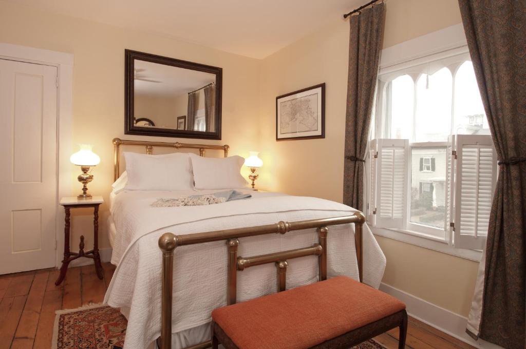 a bedroom with a bed with a mirror and a chair at Marshall Slocum Inn in Newport