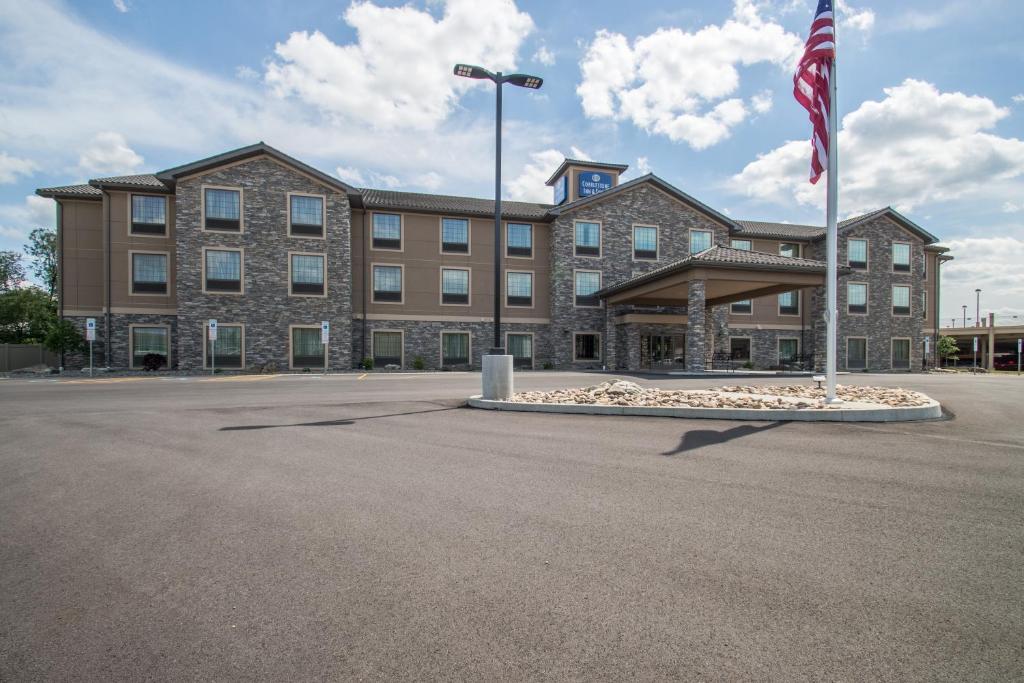 un gran edificio con una bandera delante de él en Cobblestone Inn & Suites - St Marys, en Saint Marys