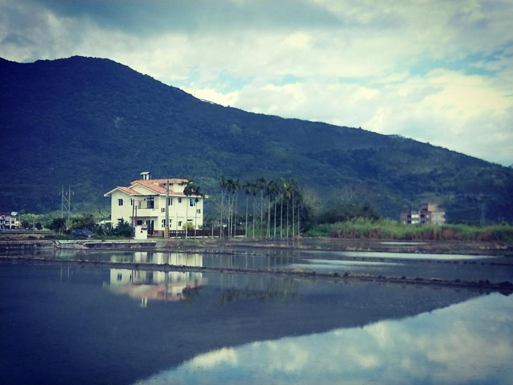 una casa seduta accanto a un corpo d'acqua di Home-Link B&B a Fenglin