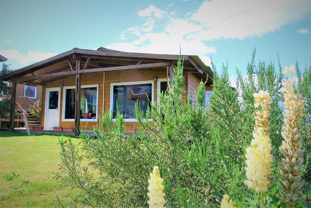 ein kleines Haus vor einem Hof mit Blumen in der Unterkunft Cabañas Del Hain in Ushuaia