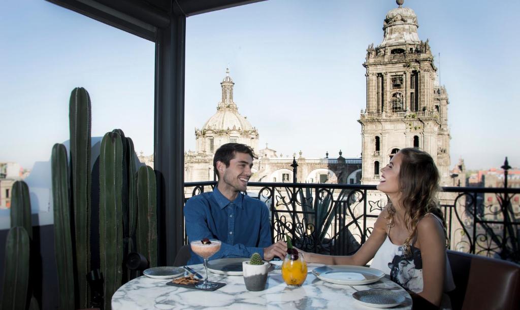 a man and woman sitting at a table in front of a restaurant at Zocalo Central in Mexico City