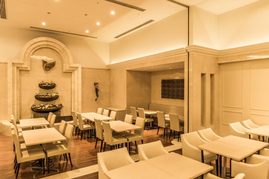 a restaurant with tables and chairs in a room at HOTEL MYSTAYS PREMIER Omori in Tokyo