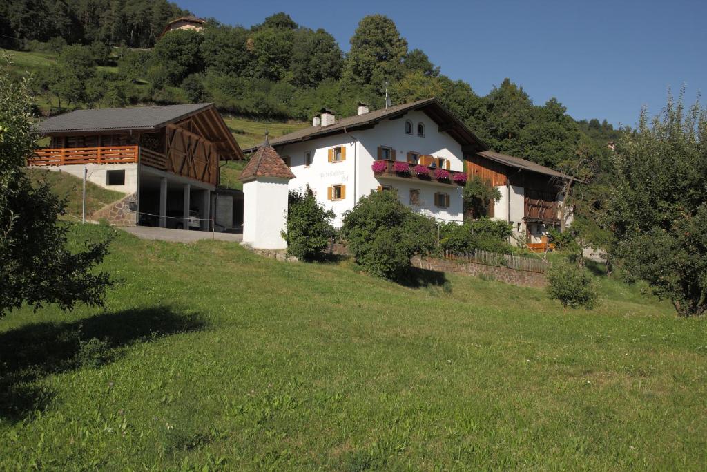 una casa en una colina con un campo verde en Paderlafoderhof, en Laion