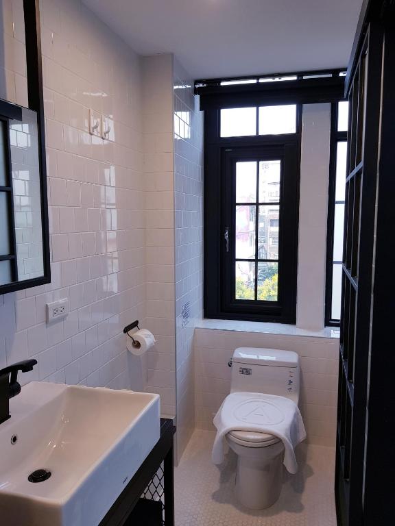 a bathroom with a toilet and a sink and a window at Art&#39;otel Ximending Taipei in Taipei