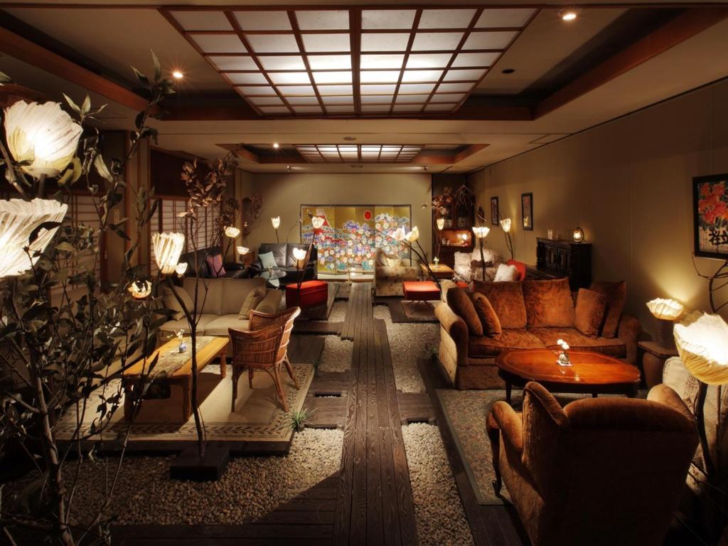 Tsukinoike في Kaminoyama: غرفة معيشة مع كنب وطاولات في غرفة