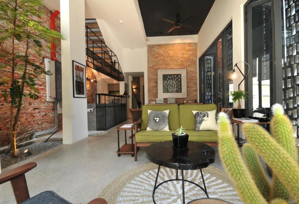- un salon avec un canapé vert et une table dans l'établissement The Nest House, à Malacca