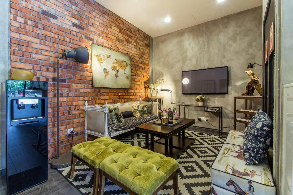 A richly styled lounge with a television, patterned seating, a tufted ottoman and a water dispenser.