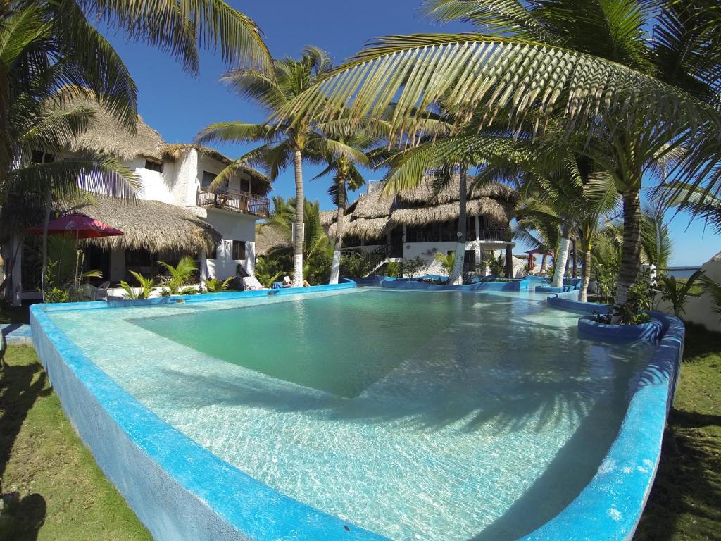 a large swimming pool with palm trees in a resort at Marbella Eco Lodge in Monterrico