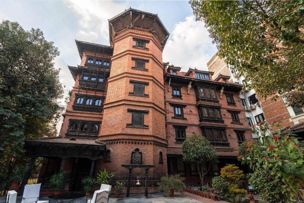 an old brick building with a clock tower on it at Kantipur Temple House in Kathmandu