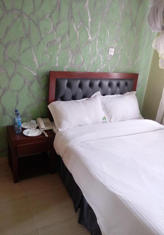 Postel nebo postele na pokoji v ubytování Ash White Hotel