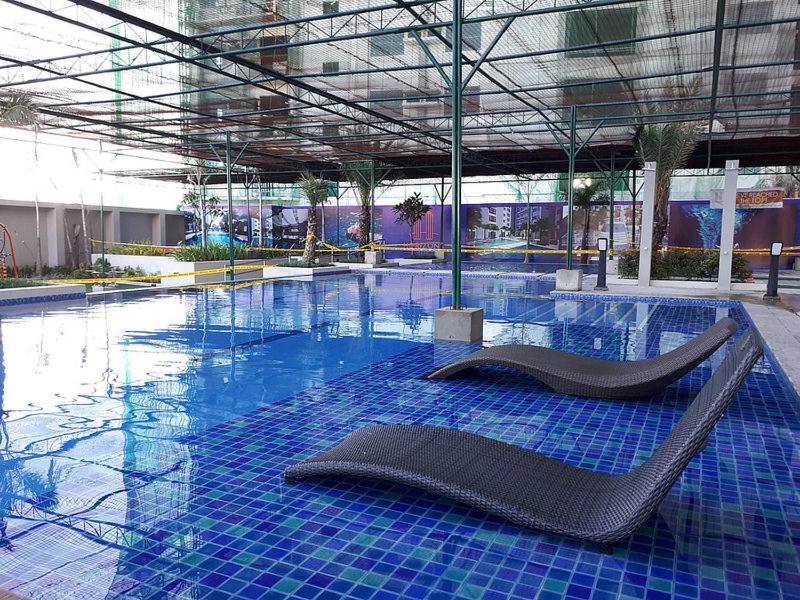 una piscina con una sedia al centro di KC Studio 1 at Horizons 101 Cebu a Cebu City