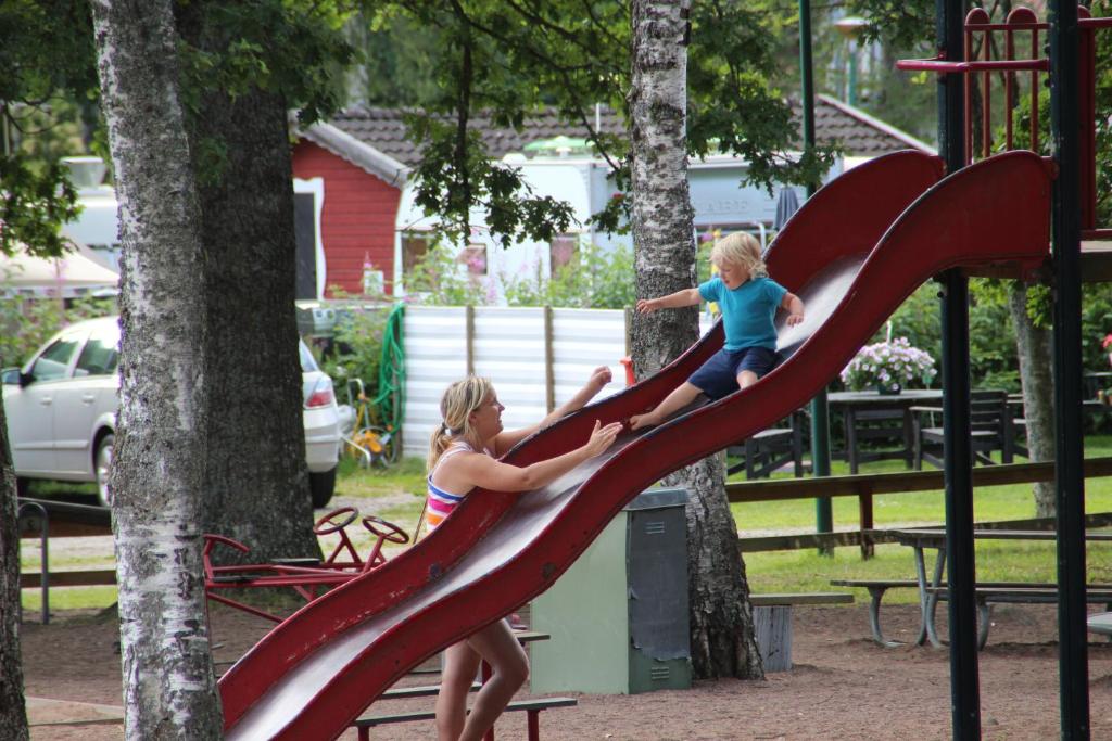 two girls playing on a slide at a playground at Eksjö Camping & Konferens in Eksjö