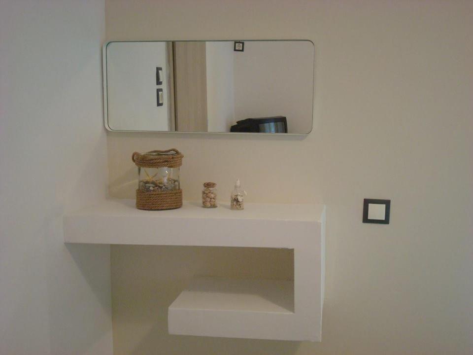 a bathroom with a mirror and a white sink at Smaragdi Studios and Rooms in Agios Kirykos