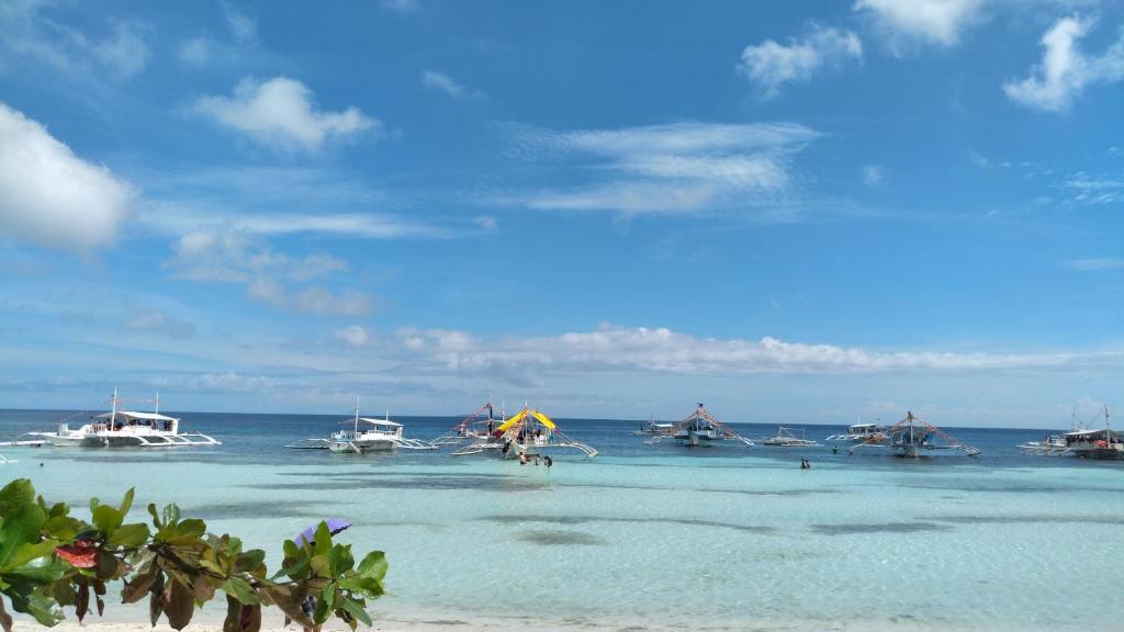 a beach with a group of boats in the water at ARAMARA Resort in Panglao