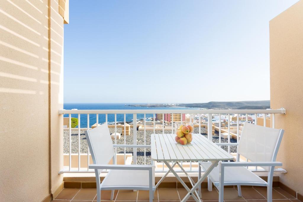 ポリス・デ・アボナにあるVista al Faroのテーブルと椅子、海の景色を望むバルコニー