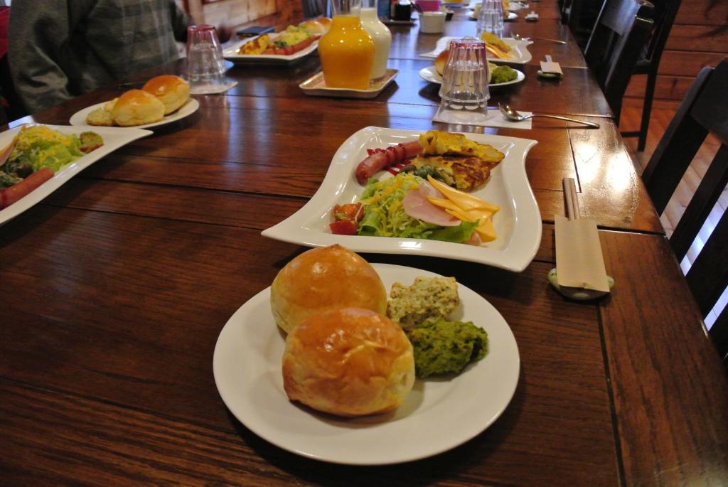 a wooden table with plates of food on it at Polan no Fue in Minamioguni