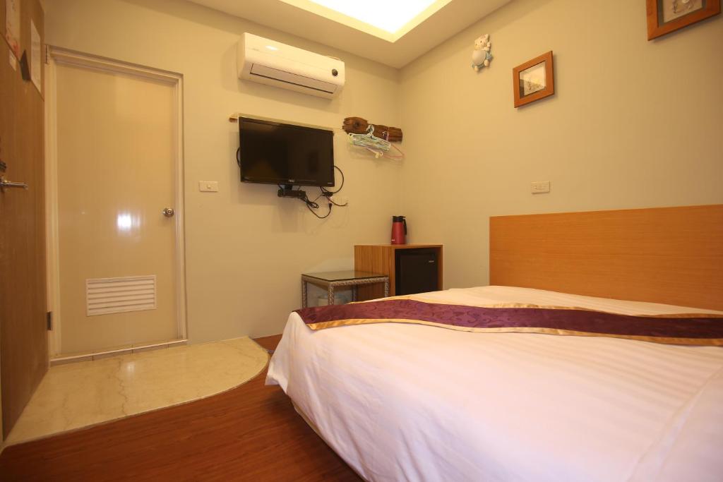 a bedroom with a bed and a flat screen tv at Kenting Waterfront Hotel in Kenting