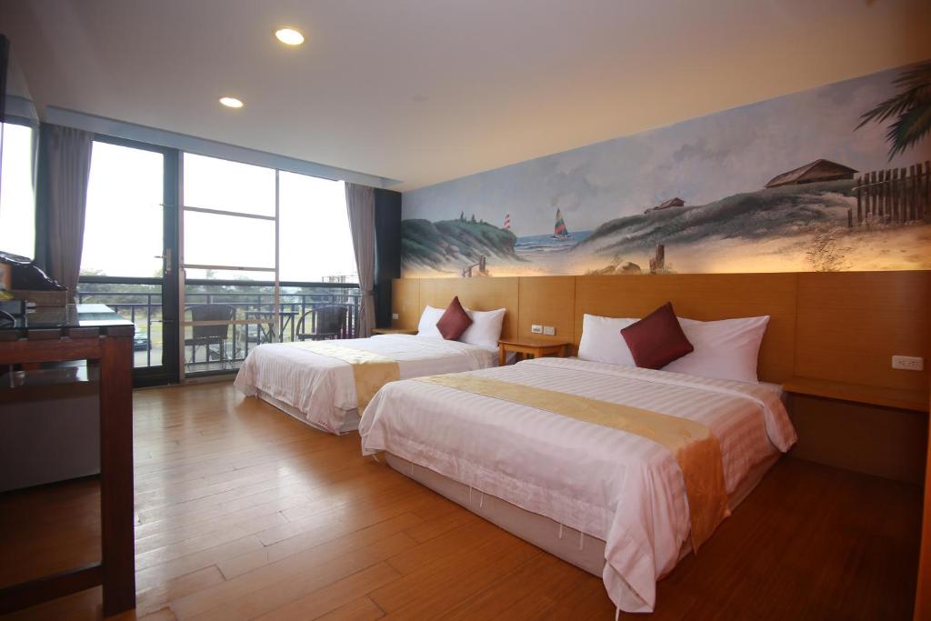 a hotel room with two beds and a painting on the wall at Kenting Waterfront Hotel in Kenting