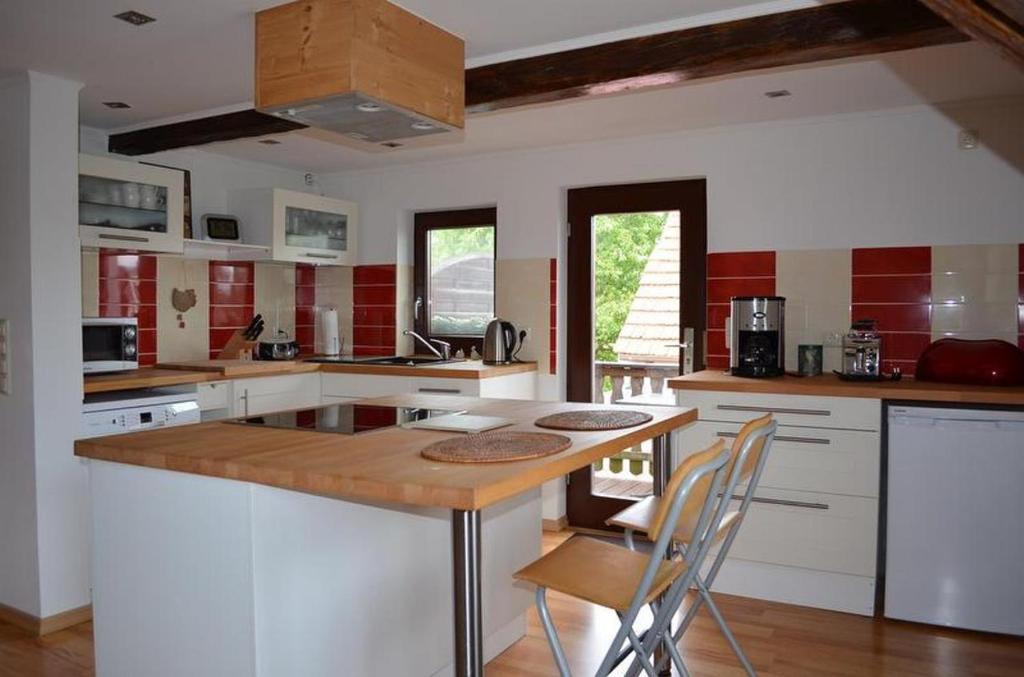 een keuken met een houten eiland met stoelen erin bij Ferienhaus Jungk in Eisenach