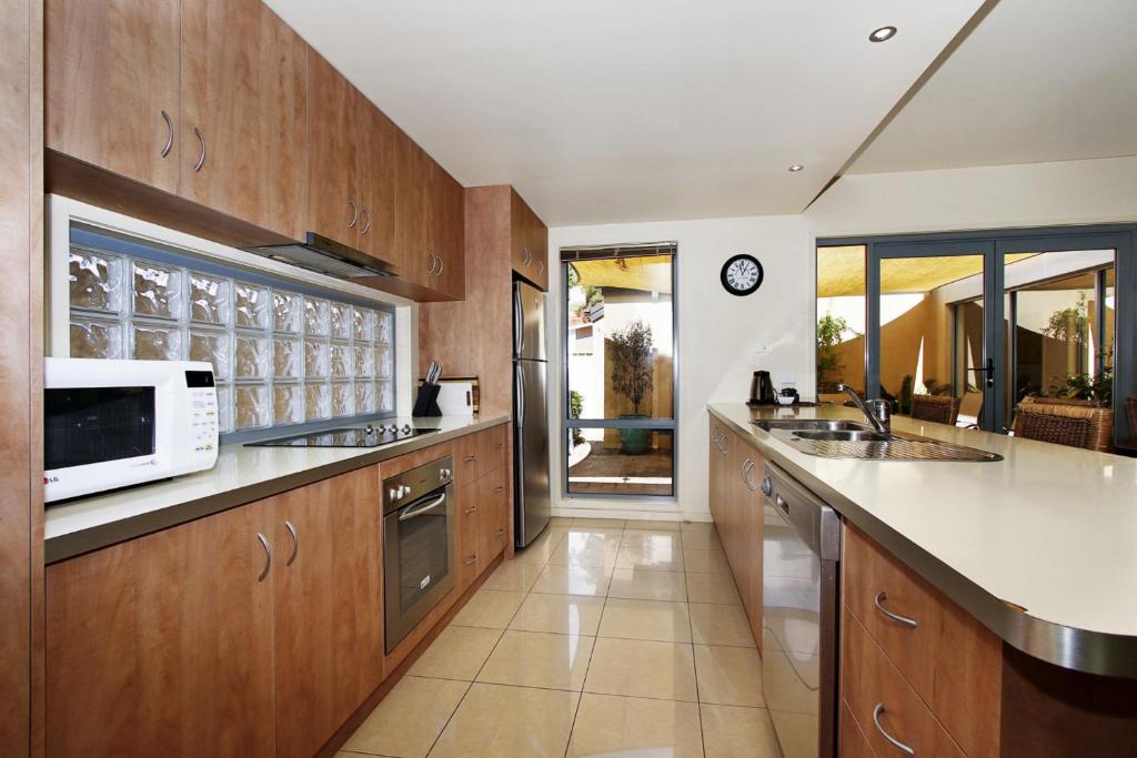 a kitchen with wooden cabinets and a microwave at Mill House in Bright