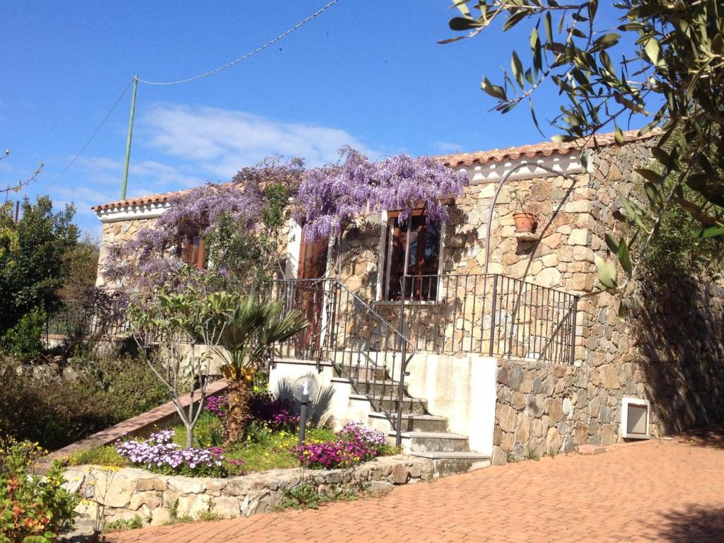 Un edificio con un mucchio di fiori viola davanti di Stazzo Isola Rossa di Gallura a Trinità dʼAgultu