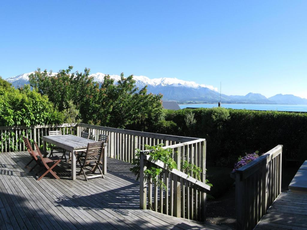 a wooden deck with a table and a fence at Dolphin Lodge in Kaikoura