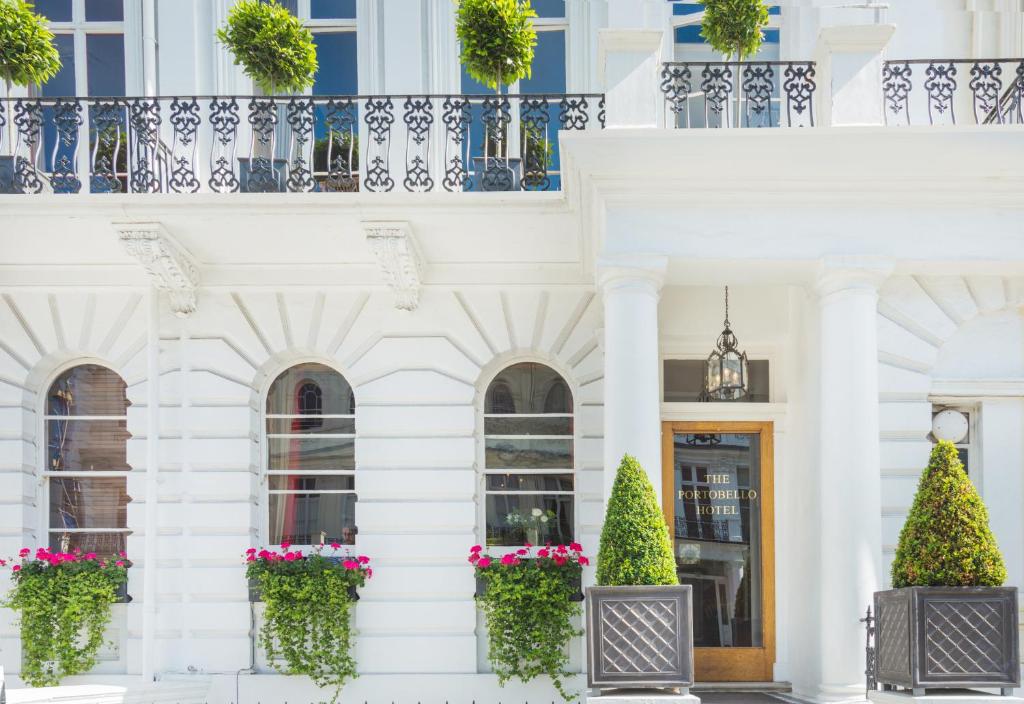 a white building with potted plants and a door at The Portobello Hotel in London