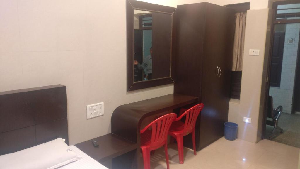 a room with two red chairs and a mirror at Hotel Sarada Nivas in Chennai