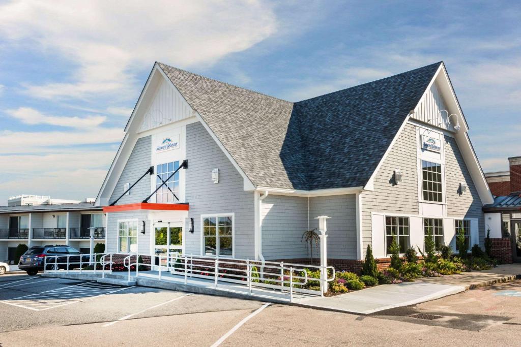 a large white building with a gambrel roof at Howard Johnson by Wyndham Middletown Newport Area in Middletown