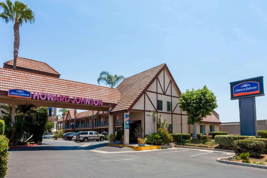 a shopping center with a sign in a parking lot at Howard Johnson by Wyndham Norco in Norco