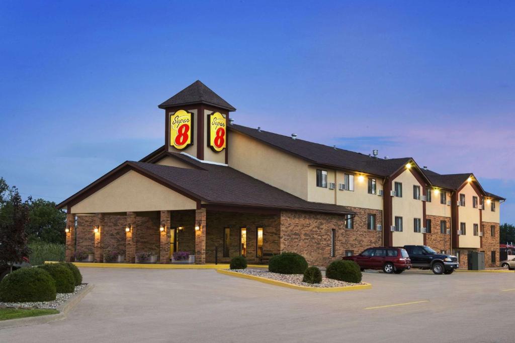 a large building with a clock tower in a parking lot at Super 8 by Wyndham Marion in Marion