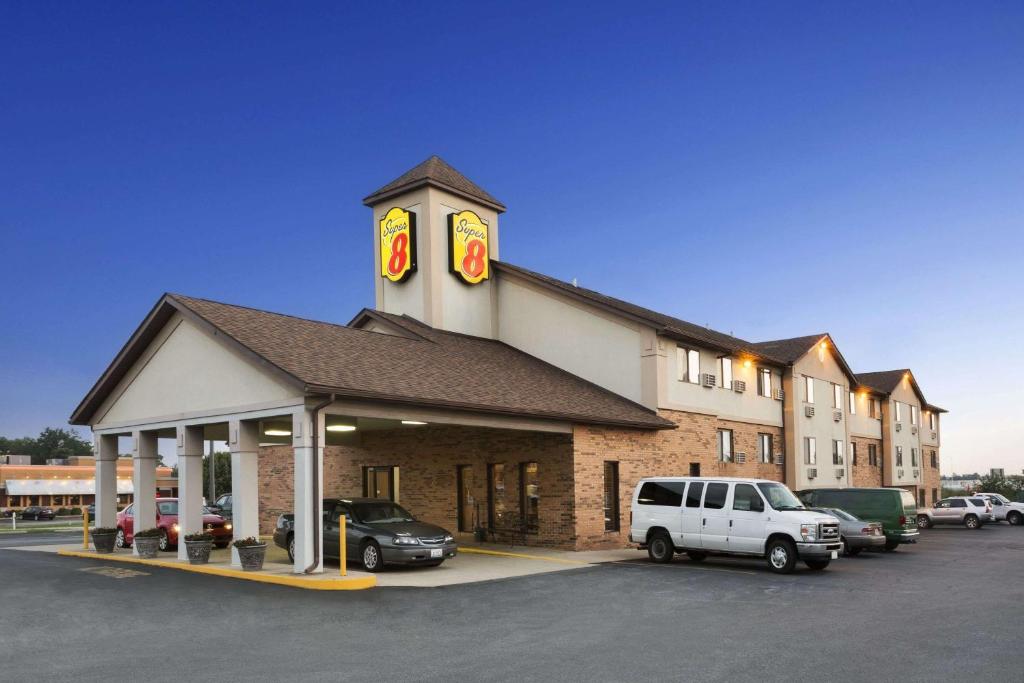 a building with a clock tower in a parking lot at Super 8 by Wyndham Mount Vernon, IL in Mount Vernon