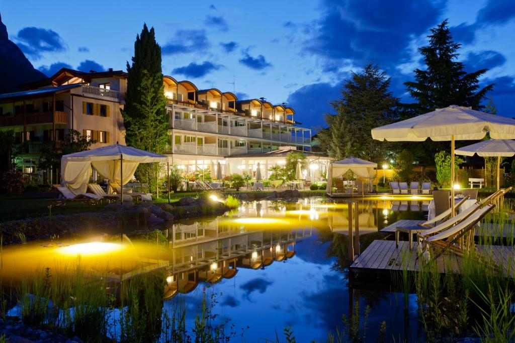 a hotel with a pool at night at Hotel Weingarten in Appiano sulla Strada del Vino
