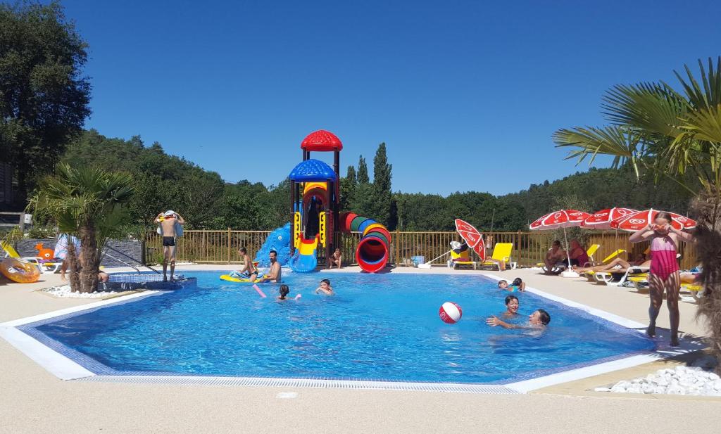 een groep mensen die in een zwembad spelen bij Le Verdoyant in Thenon