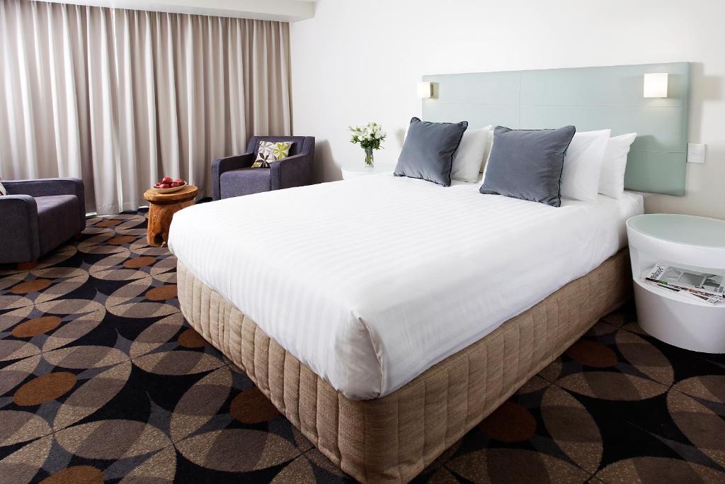 una habitación de hotel con una cama grande y una silla en The Gladstone, en Gladstone