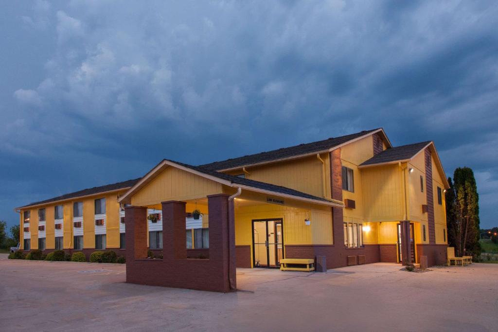 un grand bâtiment jaune avec un parking dans l'établissement Super 8 by Wyndham Anamosa IA, à Anamosa