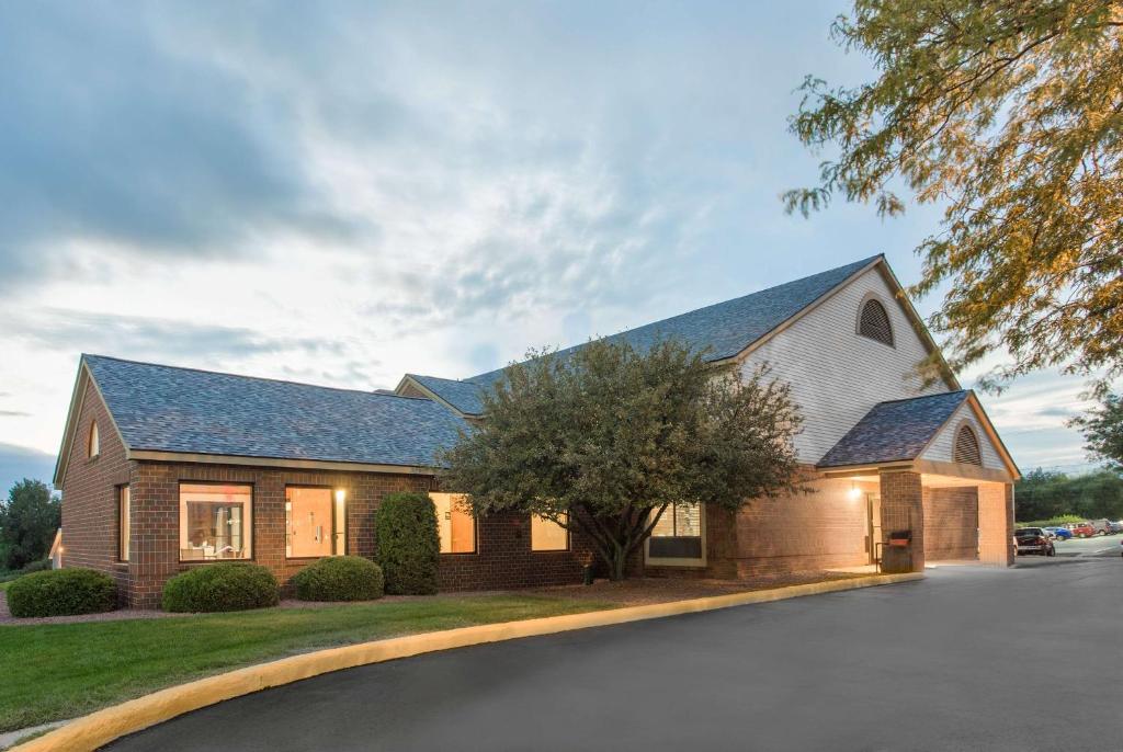 a brick house with a gambrel roof at Super 8 by Wyndham Dodgeville in Dodgeville