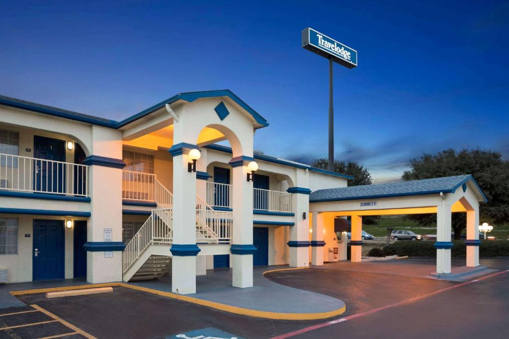 ein Hotel mit Straßenschild auf einem Parkplatz in der Unterkunft Travelodge by Wyndham Killeen/Fort Hood in Killeen