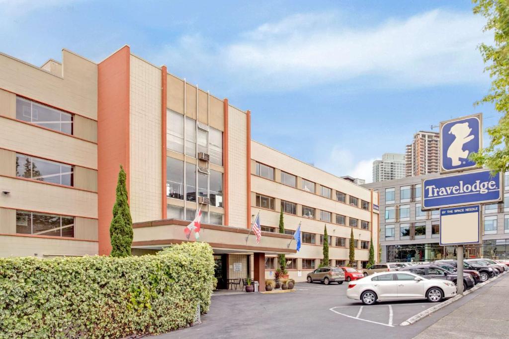 a hotel with cars parked in a parking lot at Travelodge by Wyndham Seattle By The Space Needle in Seattle